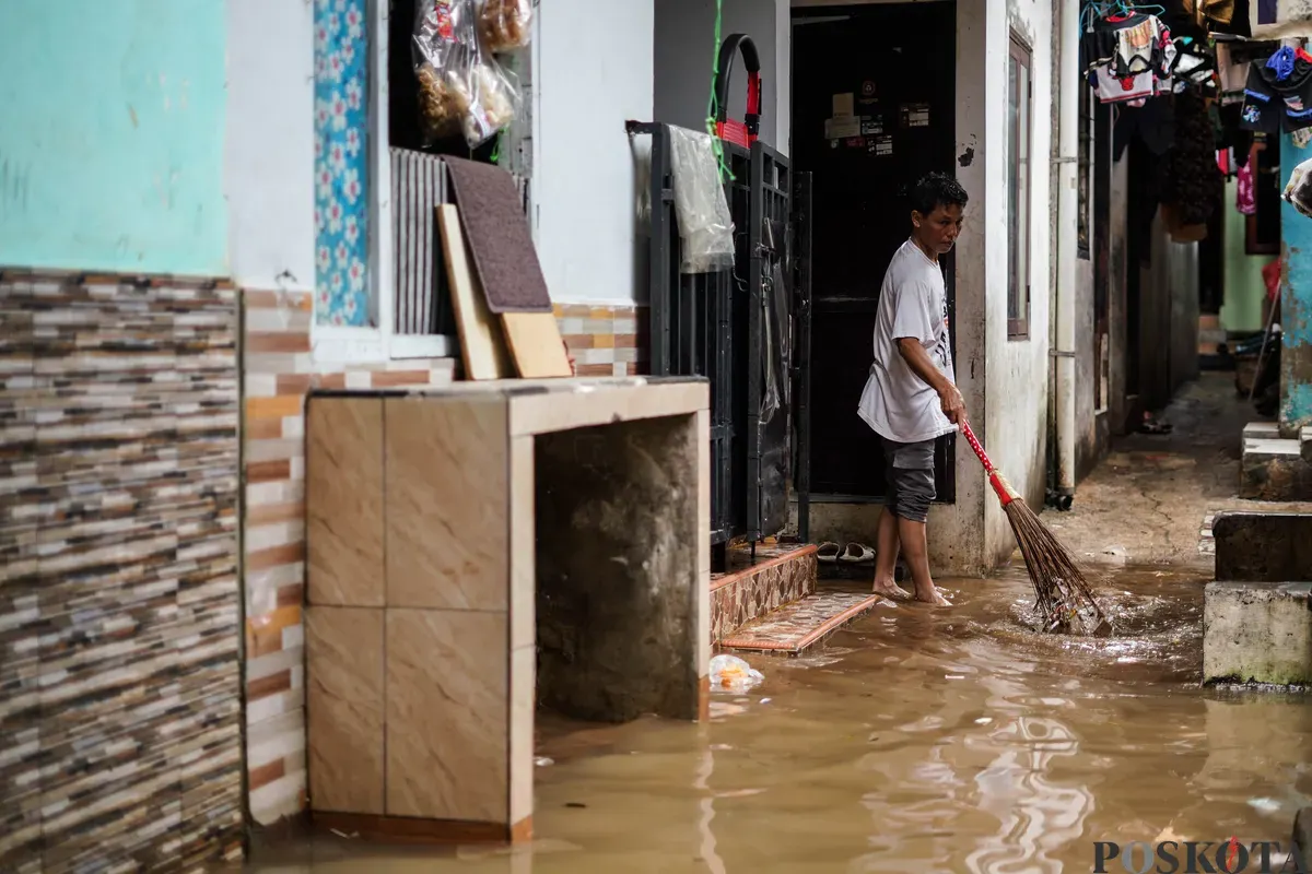 Warga berjalan melintasi banjir yang menggenangi kawasan Kebon Pala, Jakarta Timur, Jumat, 30 Januari 2026 (Sumber: Poskota/Bilal Nugraha Ginanjar)