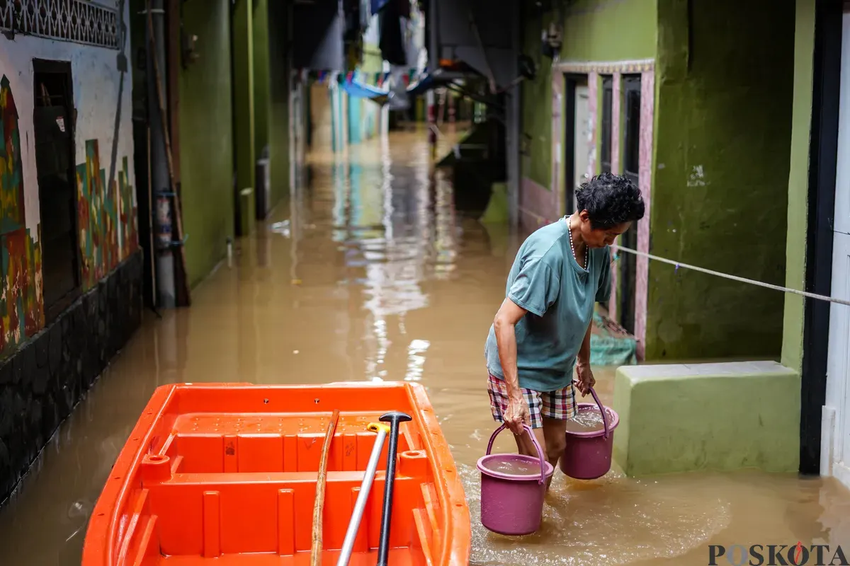Warga berjalan melintasi banjir yang menggenangi kawasan Kebon Pala, Jakarta Timur, Jumat, 30 Januari 2026 (Sumber: Poskota/Bilal Nugraha Ginanjar)