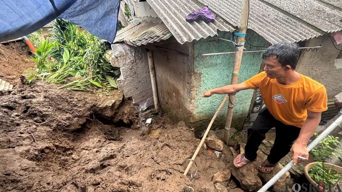 Keponakan korban, Irvan Maulana menunjukkan lokasi lansia yang meregang nyawa akibat longsor TPT di Bogor Selatan. (Sumber: Poskota/Giffar Rivana)