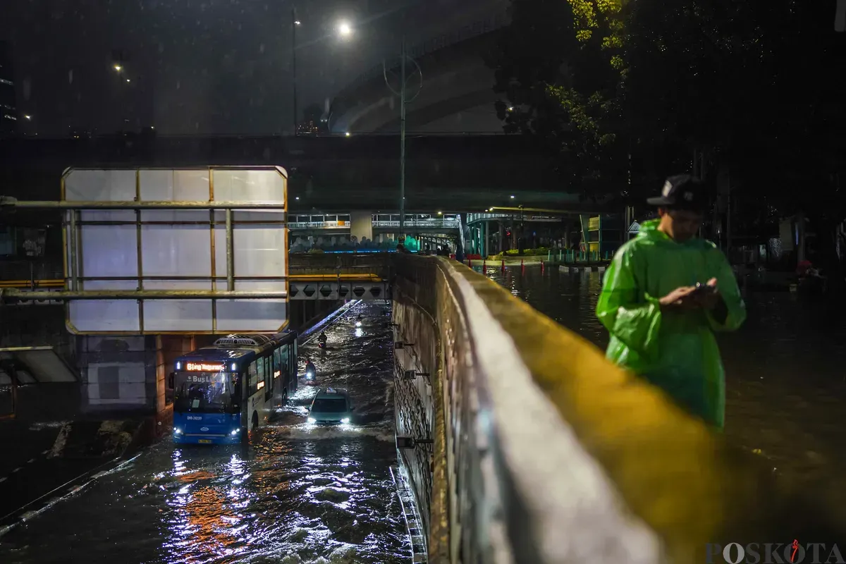 Pengendara melintasi genangan air banjir yang merendam Underpass Mampang, Jakarta Selatan, Minggu, 8 Maret 2026, dini hari. (Sumber: Poskota/Bilal Nugraha Ginanjar)