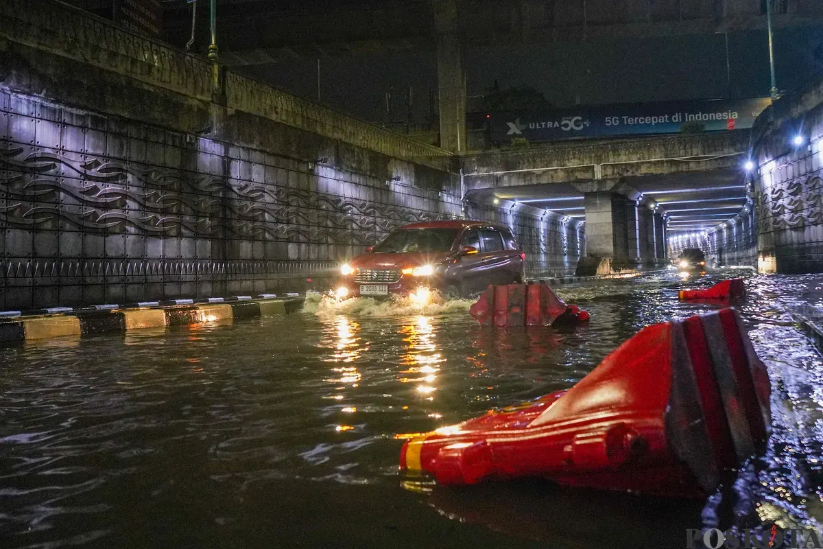 Pengendara melintasi genangan air banjir yang merendam Underpass Mampang, Jakarta Selatan, Minggu, 8 Maret 2026, dini hari. (Sumber: Poskota/Bilal Nugraha Ginanjar)