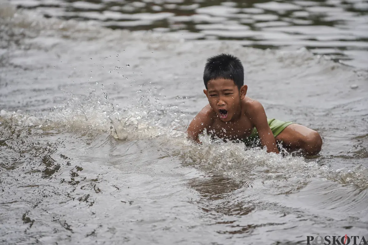Warga melintasi genagan banjir di Jalan Bendungan Hilir, Jakarta Selatan, Minggu, 8 Maret 2026. (Sumber: Poskota/Bilal Nugraha Ginanjar)