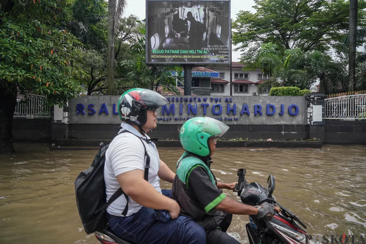 Warga melintasi genagan banjir di Jalan Bendungan Hilir, Jakarta Selatan, Minggu, 8 Maret 2026. (Sumber: Poskota/Bilal Nugraha Ginanjar)