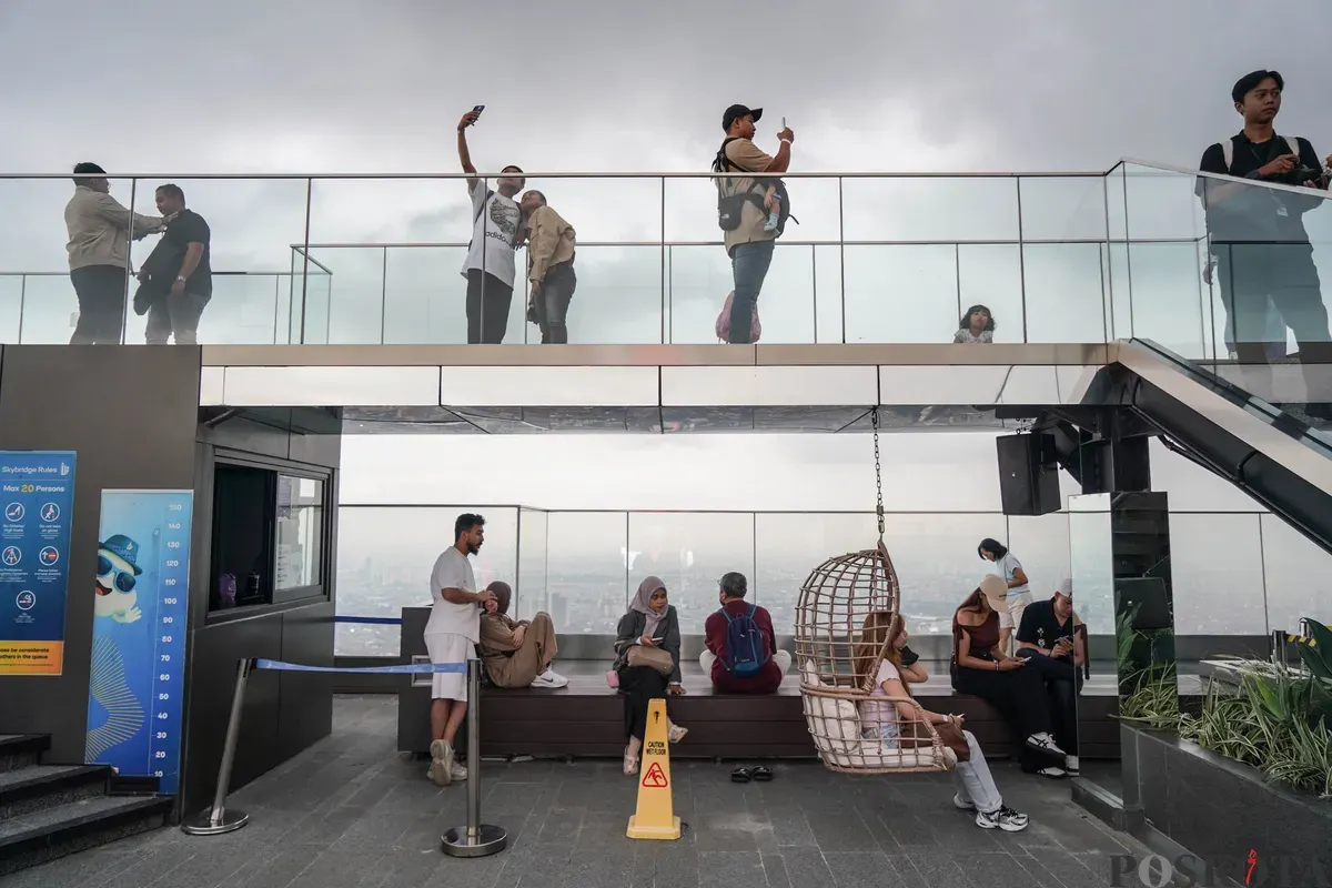Warga berfoto diatap Gedung Thamrin Nine, Jakarta, Rabu, 11 Maret 2026. (Sumber: Poskota/Bilal Nugraha Ginanjar)