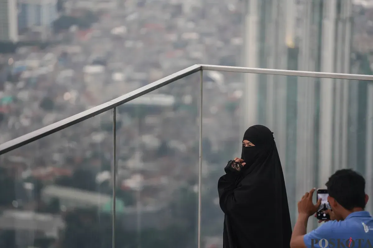 Warga berfoto diatap Gedung Thamrin Nine, Jakarta, Rabu, 11 Maret 2026. (Sumber: Poskota/Bilal Nugraha Ginanjar)