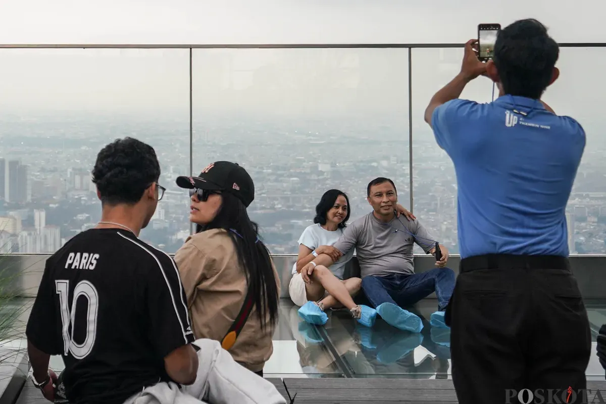 Warga berfoto diatap Gedung Thamrin Nine, Jakarta, Rabu, 11 Maret 2026. (Sumber: Poskota/Bilal Nugraha Ginanjar)