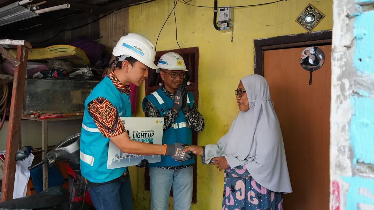 Manager PLN UP2D Jakarta, Dwi Arya Yudha (tengah) melakukan penyalaan listrik di rumah Upik dalam suasana penuh haru dan sukacita. (Sumber: Dok. PLN UID Jakarta Raya)