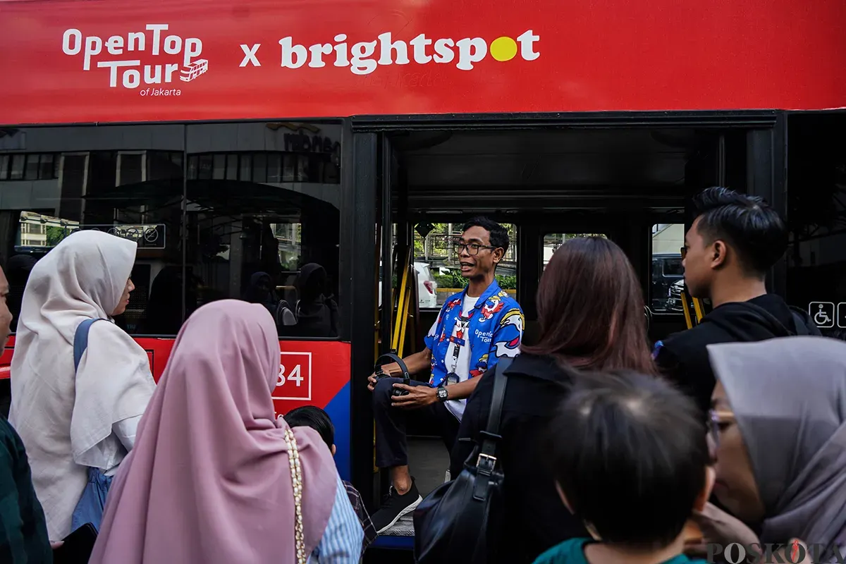 Pengunjung menikmati suasana bersama keluarga sambil berswafoto dengan latar belakang kota dari bagian atap bus wisata Open Top Tour of Jakarta, Jumat, 4 April 2025. (Sumber: Poskota/Bilal Nugraha Ginanjar)