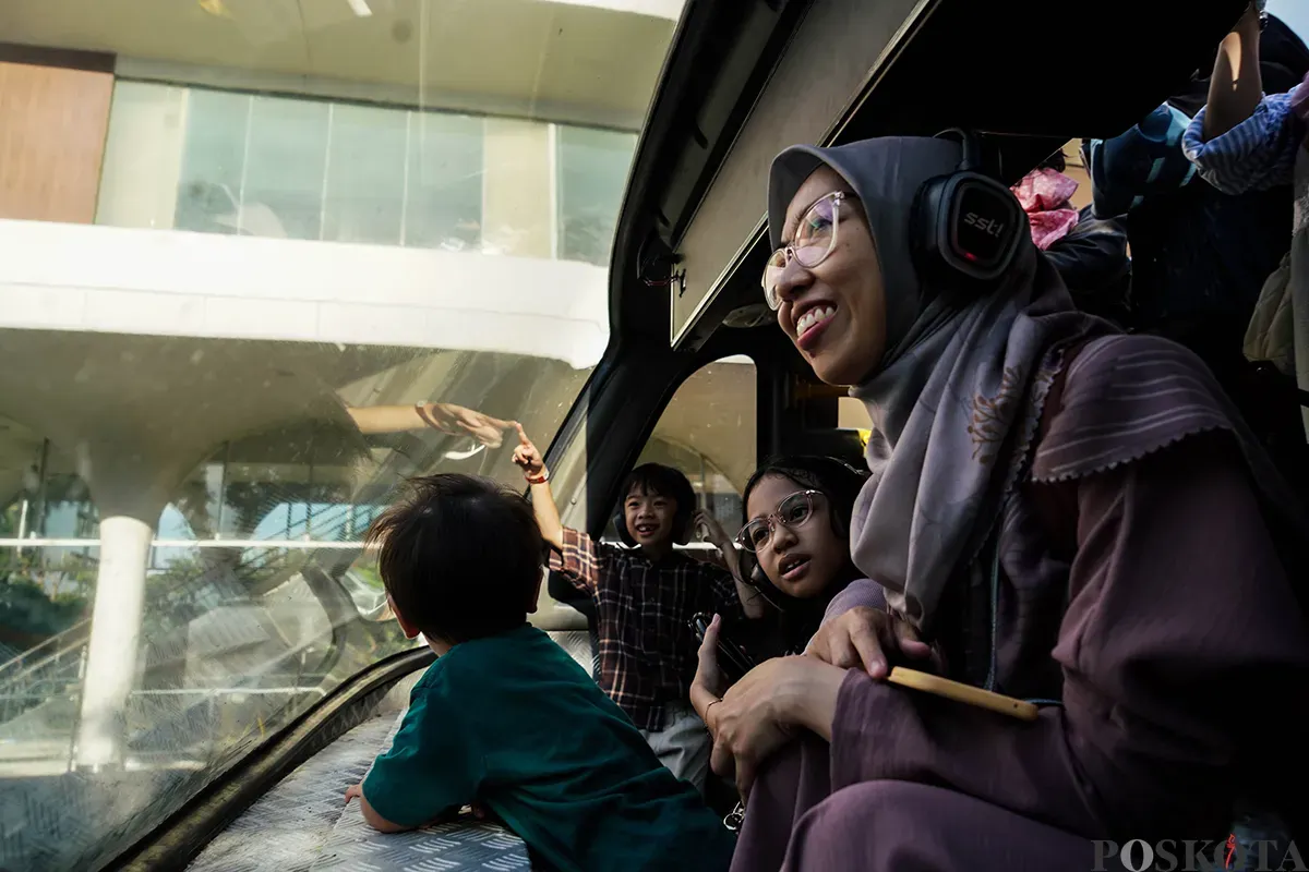 Pengunjung menikmati suasana bersama keluarga sambil berswafoto dengan latar belakang kota dari bagian atap bus wisata Open Top Tour of Jakarta, Jumat, 4 April 2025. (Sumber: Poskota/Bilal Nugraha Ginanjar)