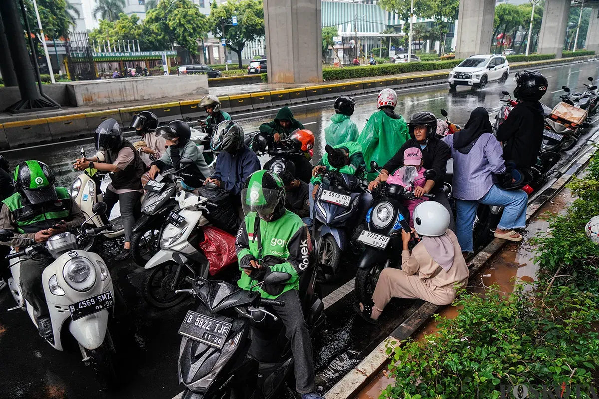 Pengendara sepeda motor menorobos hujan di Jalan Kuningan, Jakarta Selatan, Sabtu, 5 April 2025. (Sumber: Poskota/Bilal Nugraha Ginanjar)