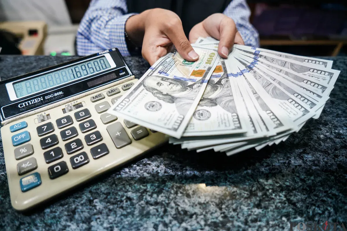 Petugas memeriksa pecahan uang dollar AS di tempat penukaran uang valuta asing PT Valuta Artha Mas di Kuningan, Jakarta Selatan, Rabu, 9 April 2025. (Sumber: Poskota/ Bilal Nugraha Ginanjar)