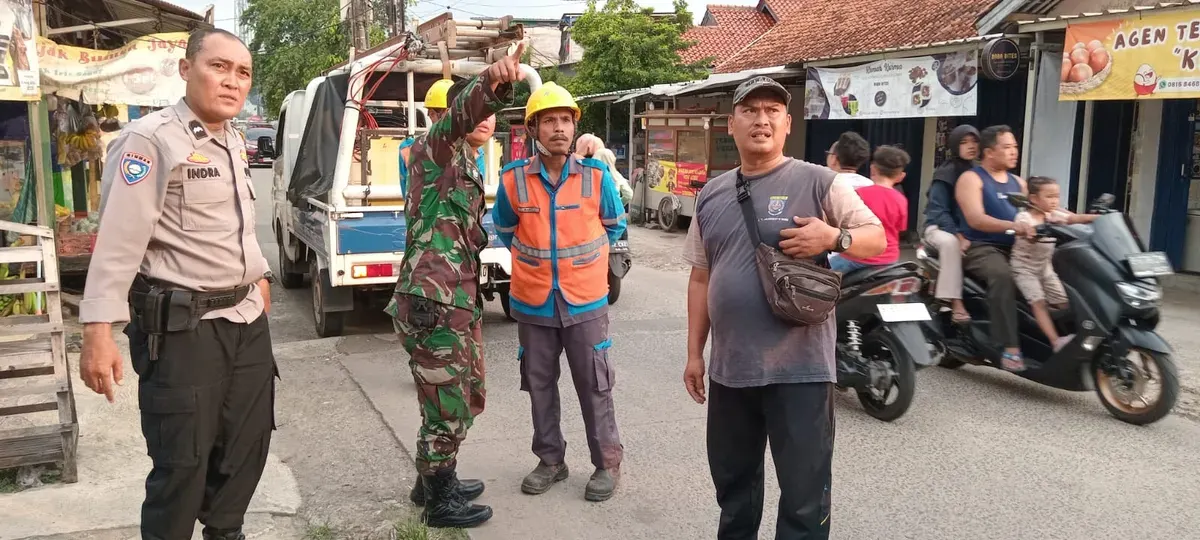 Petugas dari kepolisian dan PLN melakukan perapian pada kabel yang menjuntai di jalanan di Depok, Rabu, 9 April 2025. (Sumber: Dok. Polsek Bojongsari)