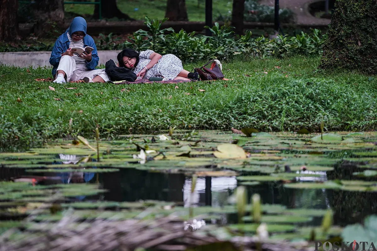 Sejumlah pengunjung menikmati suasana hutan kota dengan berbagai kegiatan seperti membaca buku, berfoto dan jalan santai di Taman Langsat, Jakarta Selatan, Sabtu 12 April 2025. (Sumber: Poskota/Bilal Nugraha Ginanjar)