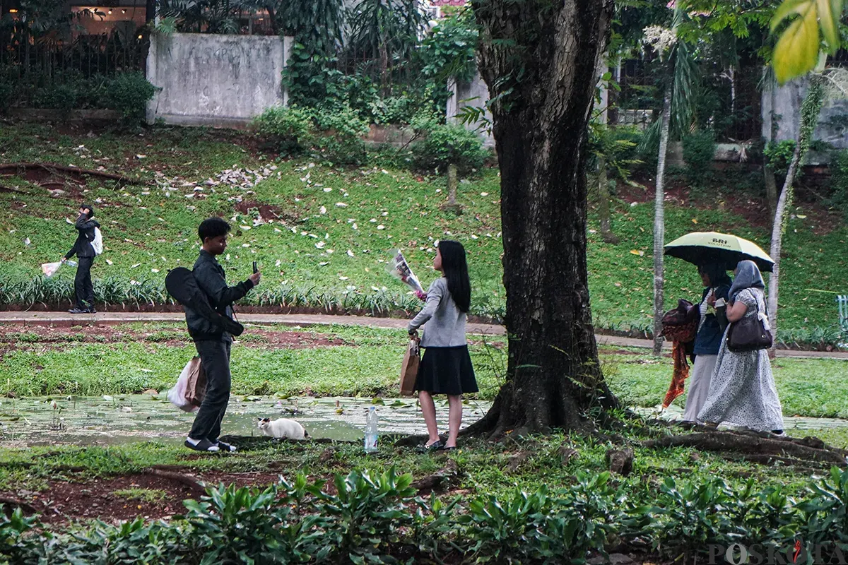Sejumlah pengunjung menikmati suasana hutan kota dengan berbagai kegiatan seperti membaca buku, berfoto dan jalan santai di Taman Langsat, Jakarta Selatan, Sabtu 12 April 2025. (Sumber: Poskota/Bilal Nugraha Ginanjar)