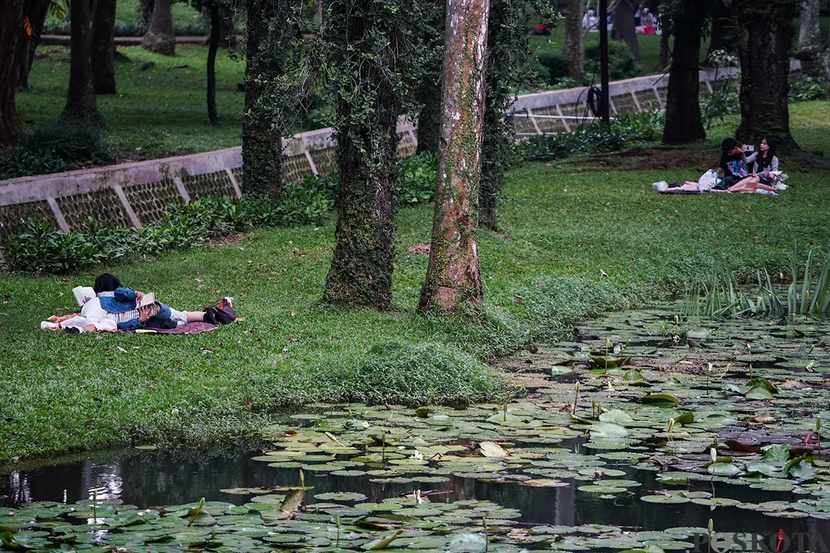 Sejumlah pengunjung menikmati suasana hutan kota dengan berbagai kegiatan seperti membaca buku, berfoto dan jalan santai di Taman Langsat, Jakarta Selatan, Sabtu 12 April 2025. (Sumber: Poskota/Bilal Nugraha Ginanjar)