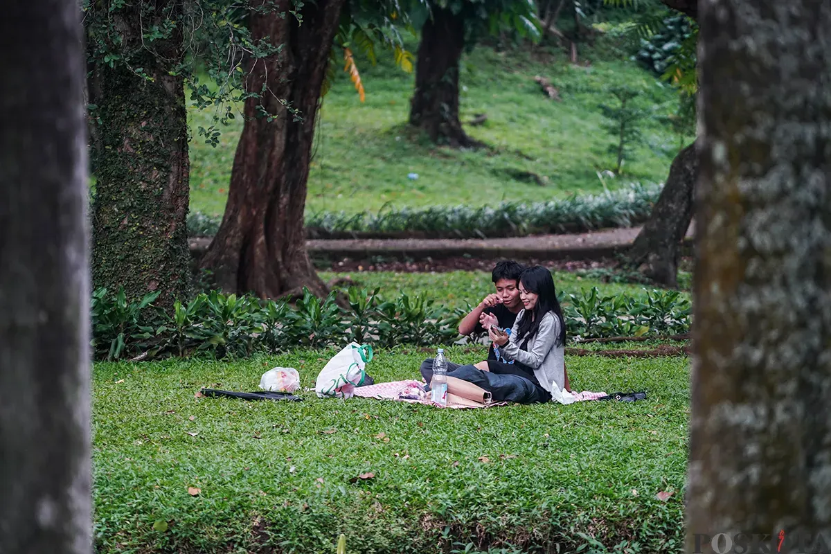 Sejumlah pengunjung menikmati suasana hutan kota dengan berbagai kegiatan seperti membaca buku, berfoto dan jalan santai di Taman Langsat, Jakarta Selatan, Sabtu 12 April 2025. (Sumber: Poskota/Bilal Nugraha Ginanjar)