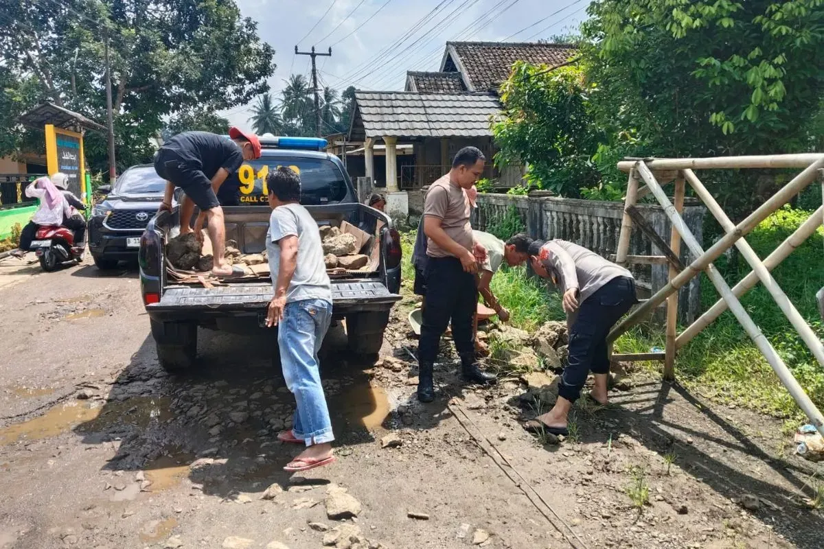 Sejumlah warga dan anggota melakukan perbaikan jalan rusak di Cikedal, Kabupaten Pandeglang. (Sumber: Dok. Polsek Cikedal)
