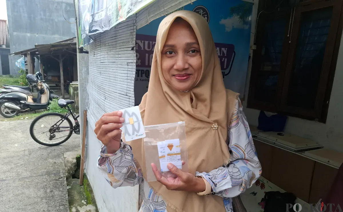 Tatun, warga Pamulang, senang berhasil membeli emas logam mulia Antam saat harga emas sedang tinggi, Selasa 15 April 2025. (Sumber: Poskota/Angga Pahlevi)