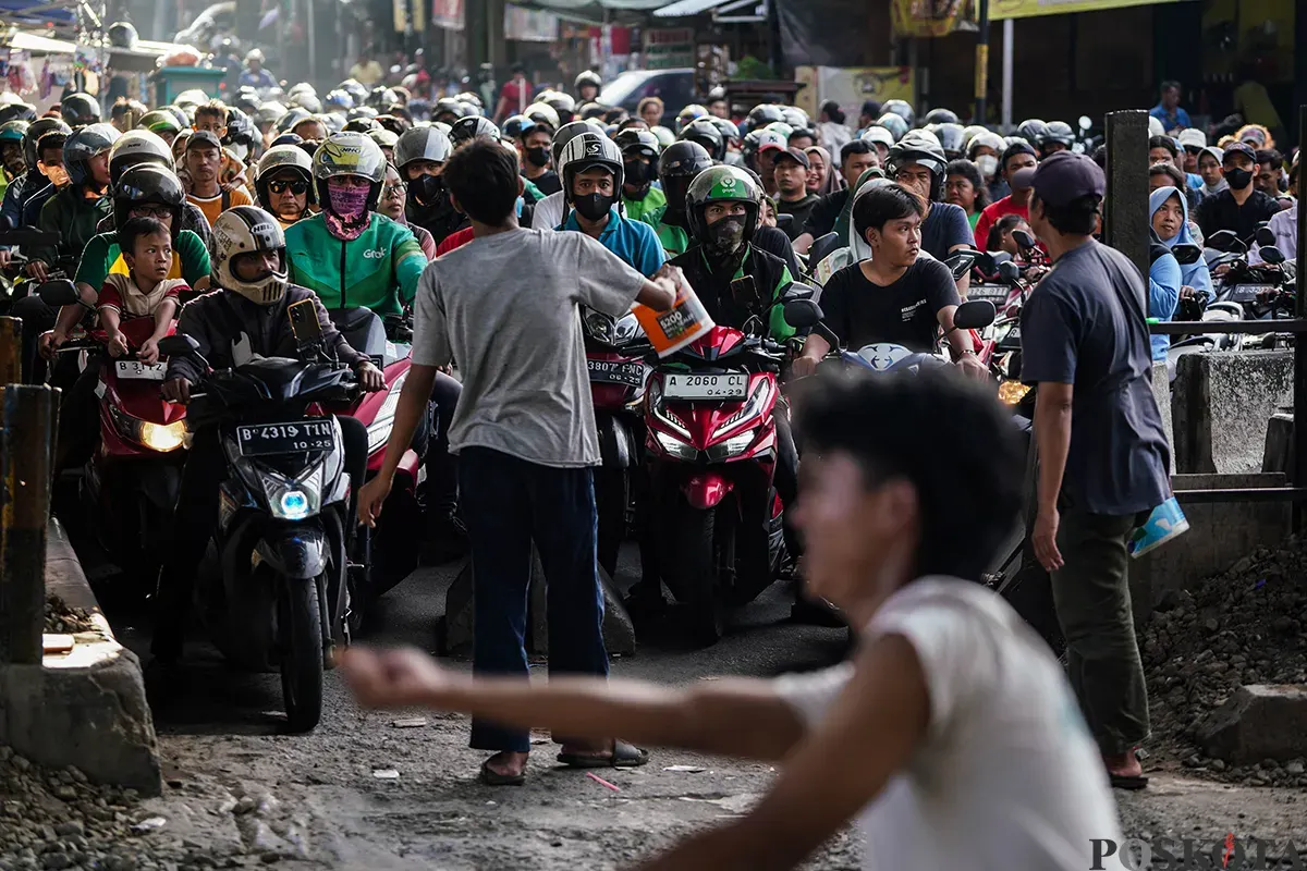 Sejumlah pengendara sepeda motor mengantre saat melintasi akses perlintasan kereta api tanpa palang pintu di bawah Fylover Roxy, Duri, Jakarta, Senin (14/4). (Sumber: Poskota/Bilal Nugraha Ginanjar)