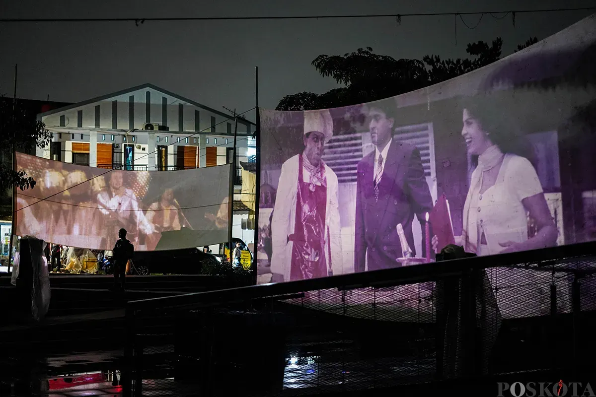 Operator film layar tancap memutarkan rol film era menggunakan mesin proyektor di Waduk Lebak Bulus, Jakarta Selatan, Jum'at, 18 April 2025. (Sumber: Poskota/Bilal Nugraha Ginanjar)