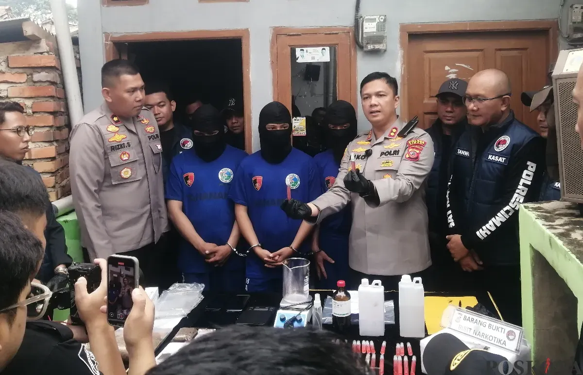 Kapolres Cimahi AKBP Niko Nurallah Adi Putra, menunjukkan barang bukti cairan bahan baku tembakau sintetis di sebuah rumah kontrakan, di wilayah Kelurahan Padasuka, Kota Cimahi, Jumat 18 April 2025. (Sumber: Poskota/Gatot Poedji Utomo)