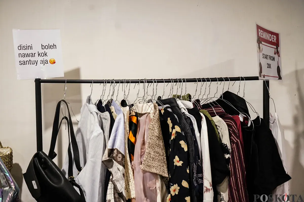 Pengunjung memilah dan memilih aneka merek pakaian bekas atau preloved yang sempat dikenakan oleh sejumlah influencer di lapak penjualan busana di Kuru Ground, Tebet, Jakarta Selatan, Sabtu, 19 April 2025. (Sumber: Poskota/Bilal Nugraha Ginanjar)
