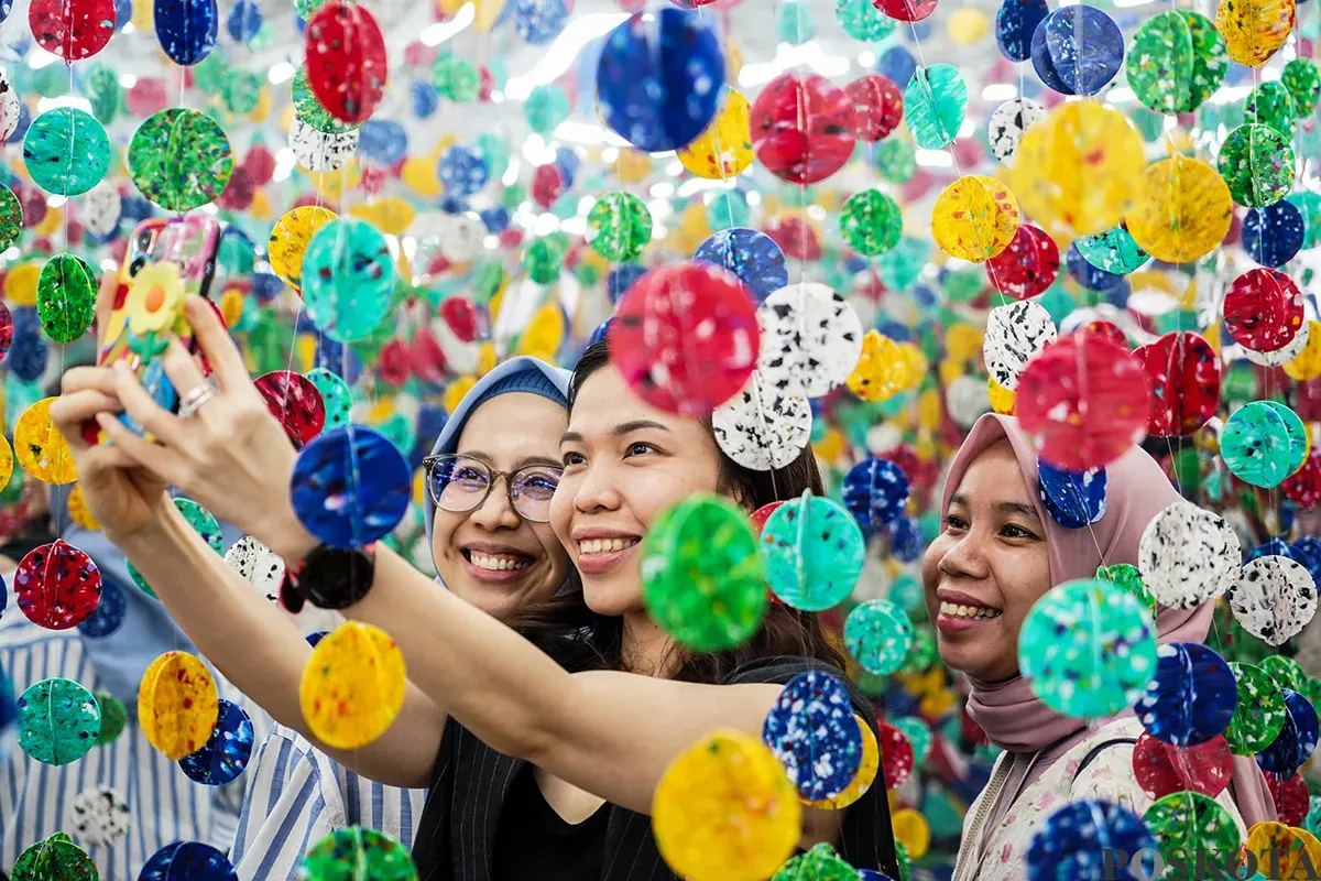 Pengunjung melihat karya instalasi yang ditampilkan pada pameran Art Jakarta Gardens di Hutan Kota Plataran, Senayan Jakarta, Selasa, 22 April 2025. (Sumber: Poskota/Bilal Nugraha Ginanjar)