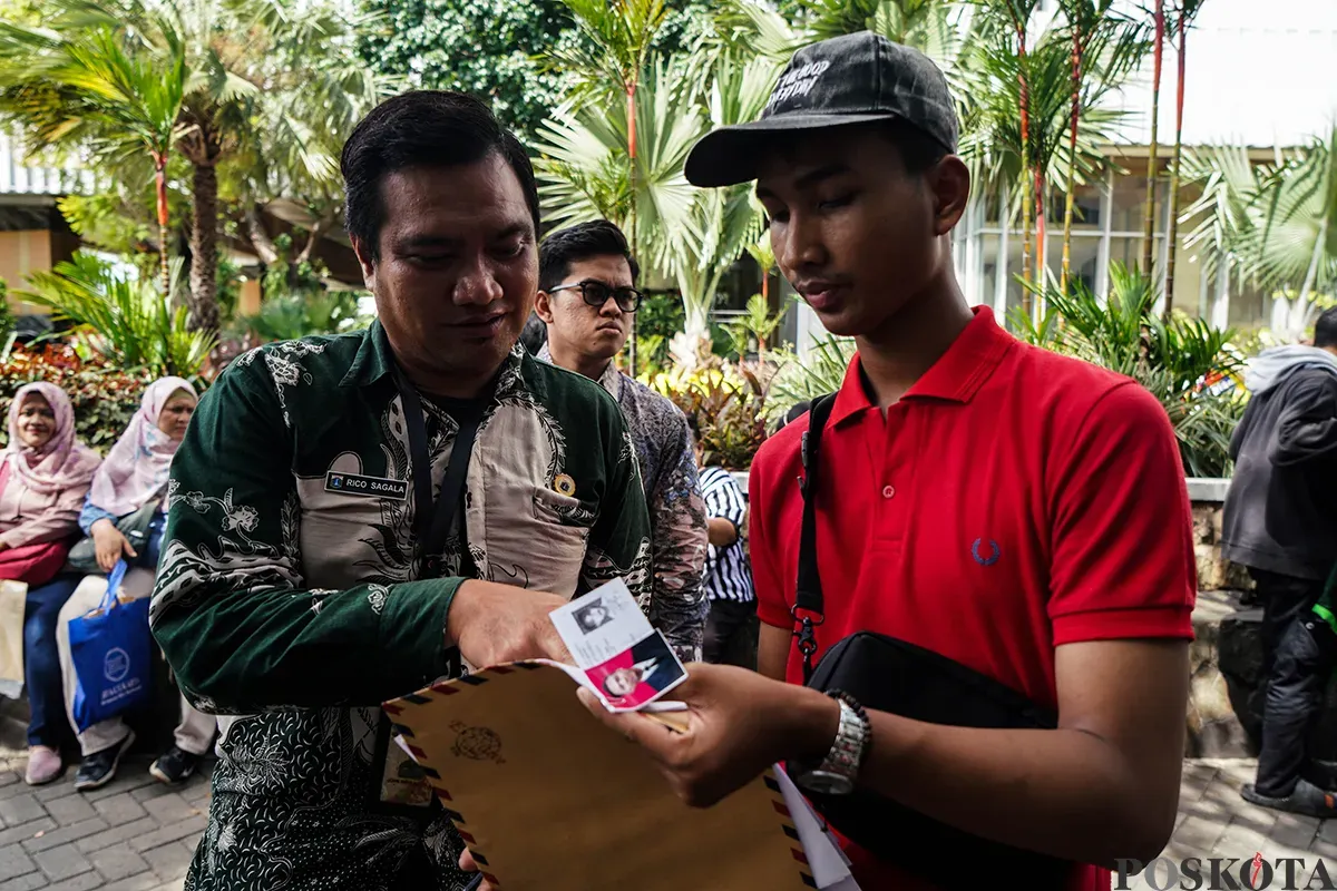 Warga memadati loket penerimaan surat dan barang sambil membawa amplop lamaran pekerjaan saat melamar kerja sebagai petugas di Penyedia Jasa Lainnya Perorangan (PJLP) di Balai Kota, Jakarta, Rabu, 23 April 2025. (Sumber: Poskota/Bilal Nugraha Ginanjar)