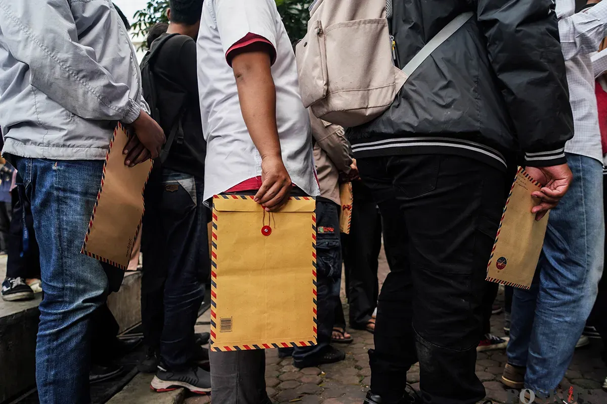Warga memadati loket penerimaan surat dan barang sambil membawa amplop lamaran pekerjaan saat melamar kerja sebagai petugas di Penyedia Jasa Lainnya Perorangan (PJLP) di Balai Kota, Jakarta, Rabu, 23 April 2025. (Sumber: Poskota/Bilal Nugraha Ginanjar)