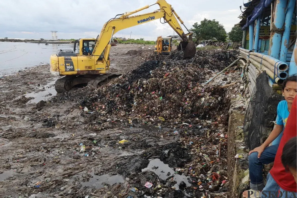 Alat berat mengeruk tumpukan sampah di Pantai Teluk, Kecamatan Labuan, Kabupaten Pandeglang, Kamis, 24 April 2025. (Sumber: Poskota/Samsul Fatoni)