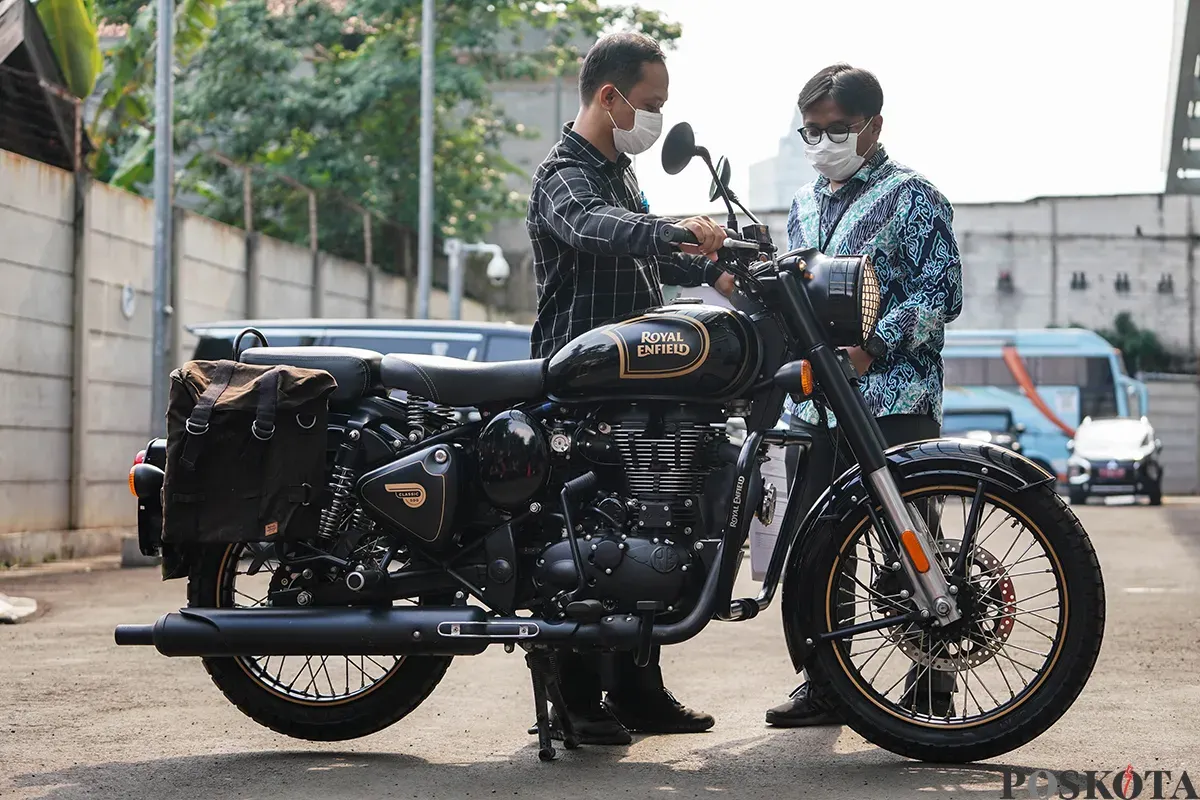 Petugas menginspeksi sepeda motor merek Royal Enfield milik mantan Gubernur Jawa Barat sekaligus terduga kasus korupsi Ridwan Kamil (RK) di Rumah Penyimpanan Benda Sitaan Negara, Cawang, Jakarta Timur, Jum'at, 25 April 2025. (Sumber: Poskota/Bilal Nugraha Ginanjar)