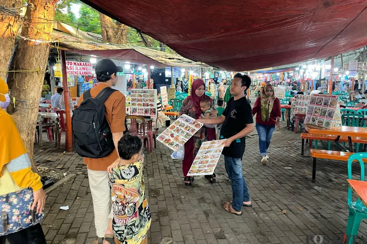 Pedagang makanan di Monas menawarkan menu makanan kepada pelanggan, Minggu, 27 April 2025. (Sumber: Poskota/Pandi Ramedhan)