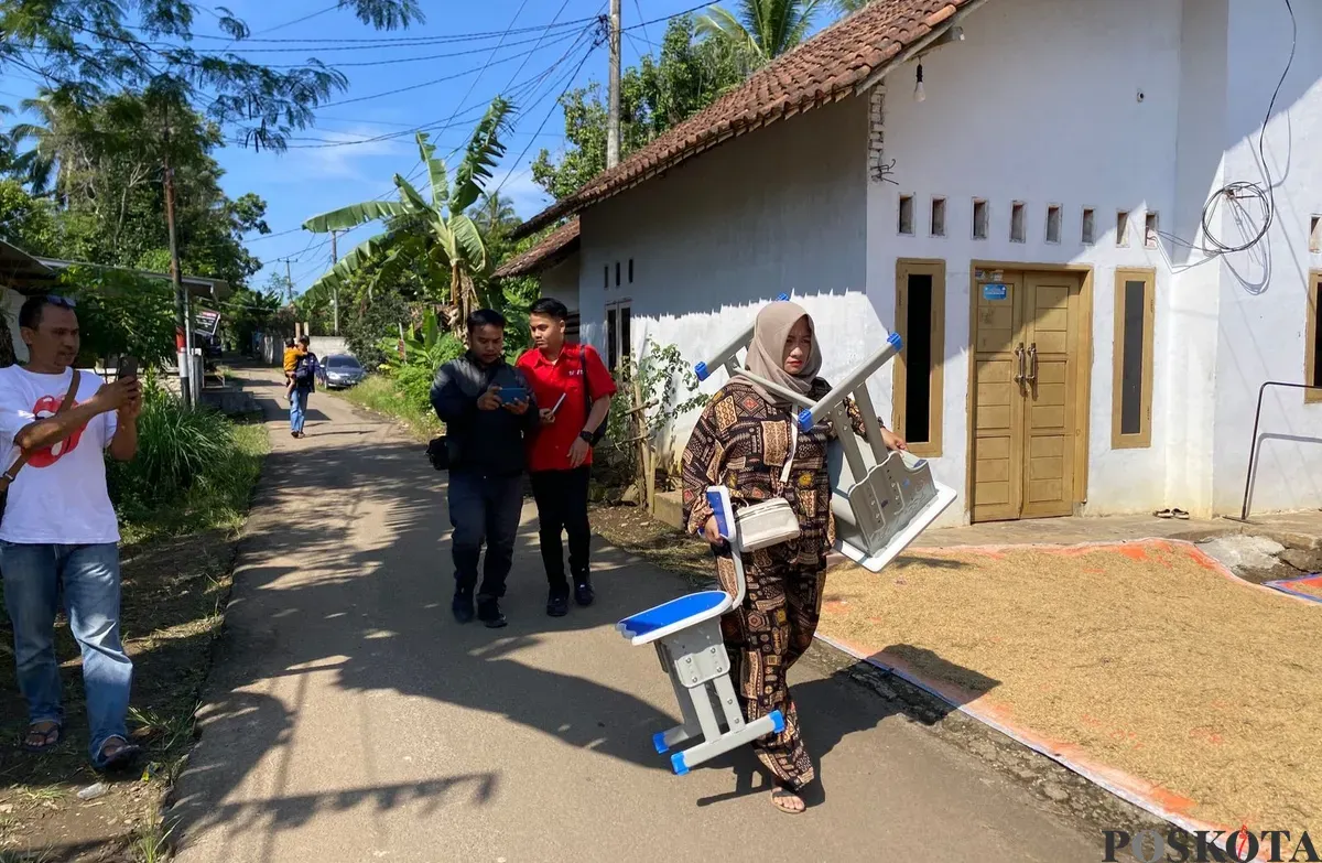 Orang tua siswa SDN 2 Pasirtangkil di Kecamatan Warunggunung, Lebak, saat memikul sepasang mebeler ke sekolah. Ia diminta pihak sekolah untuk mengganti satu set meja dan kursi yang rusak. (Sumber: Poskota/Samsul Fatoni)