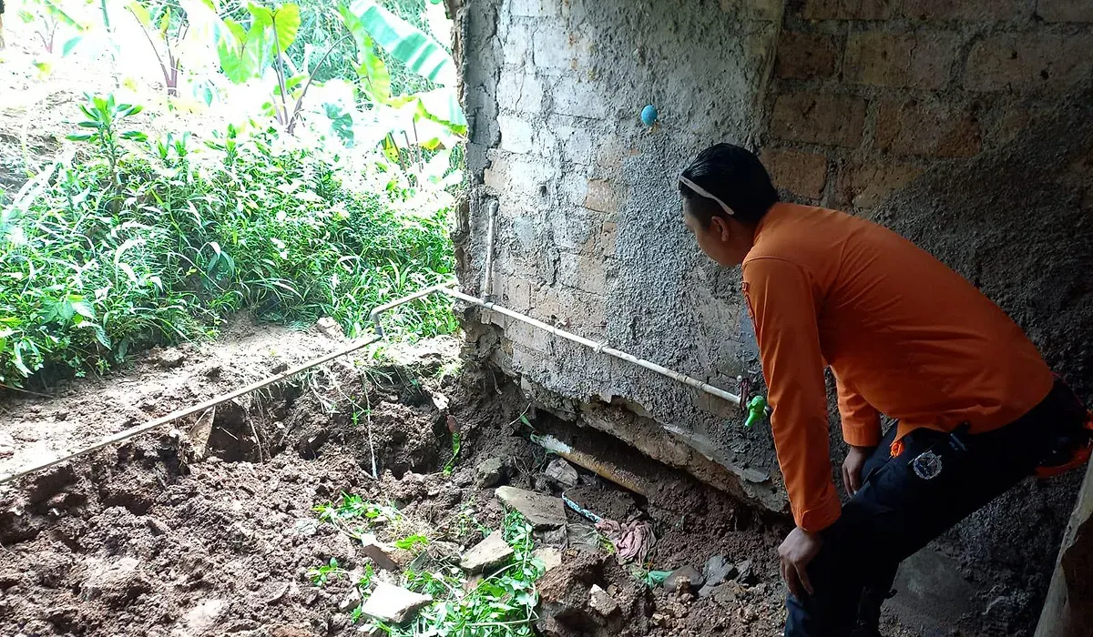 Petugas BPBD Kota Bogor mengecek kondisi rumah yang rusak akibat tanah ambles di Kampung Margabakti, Kelurahan Kertamaya, Kecamatan Bogor Selatan. (Sumber: Dok. BPBD Kota Bogor)