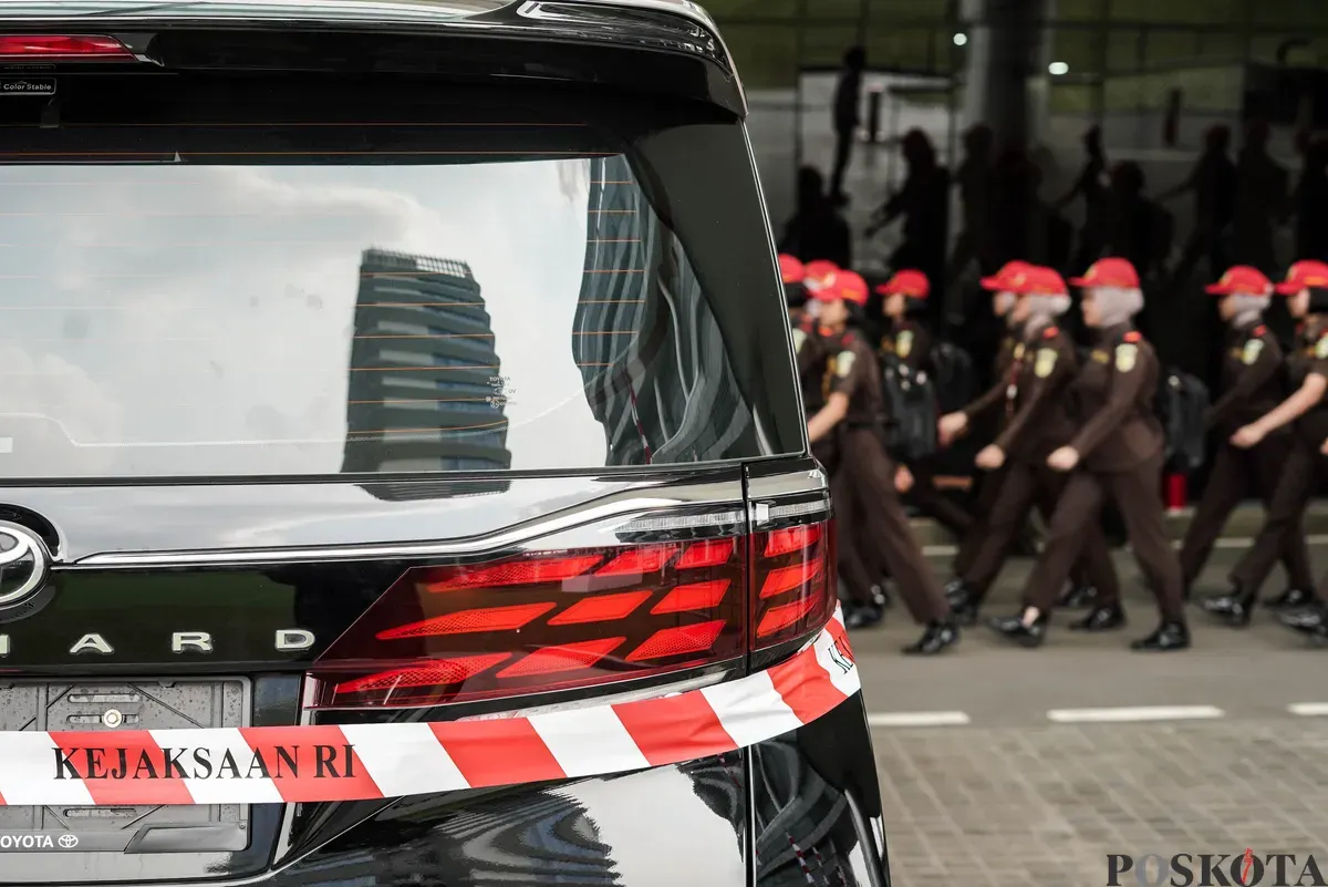 Jurnalis merekam sejumlah mobil sitaan penyidik Jaksa Agung Muda Bidang Tindak Pidana Khusus (Jampidsus) di Kejaksaan Agung, Jakarta, Selasa, 5 Agustus 2025. (Sumber: Poskota/Bilal Nugraha Ginanjar)