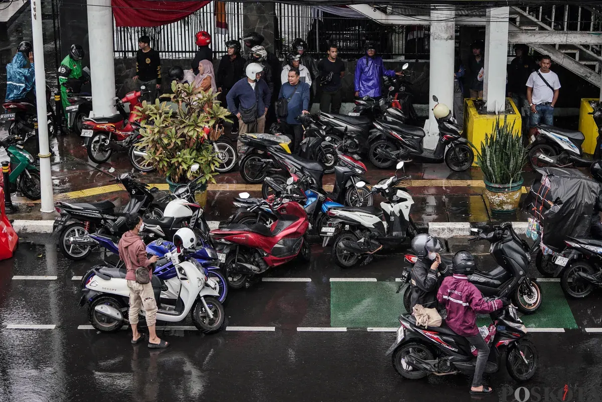 Sejumlah pengendara sepeda motor menerobos hujan di Jalan Salemba, Jakarta, Selasa, 12 Agustus 2025. Badan Meteorologi, Klimatologi, dan Geofisika (BMKG) memprakirakan hujan ringan di seluruh wilayah Jakarta. (Sumber: Poskota/Bilal Nugraha Ginanjar)
