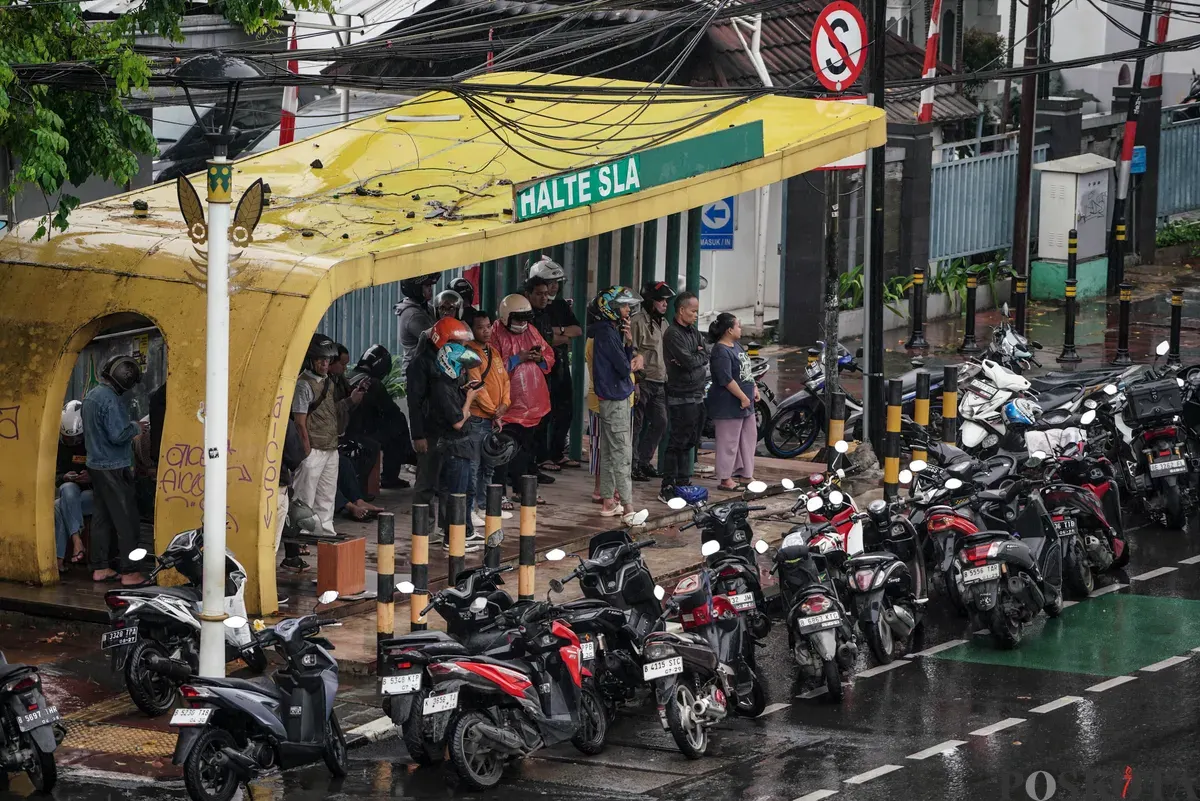 Sejumlah pengendara sepeda motor menerobos hujan di Jalan Salemba, Jakarta, Selasa, 12 Agustus 2025. Badan Meteorologi, Klimatologi, dan Geofisika (BMKG) memprakirakan hujan ringan di seluruh wilayah Jakarta. (Sumber: Poskota/Bilal Nugraha Ginanjar)