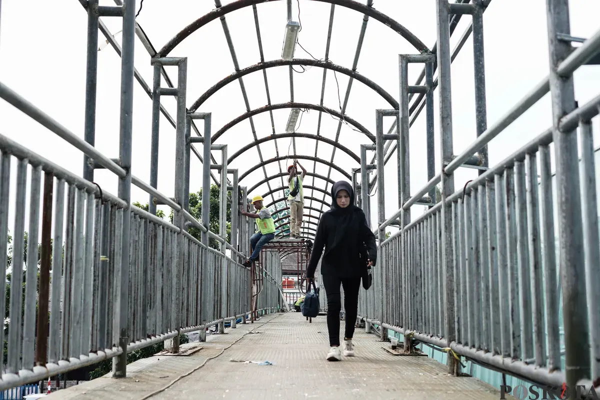 Petugas memperbaiki Jembatan Penyeberangan Orang (JPO) di Jalan Cempaka Putih, Jakarta, Rabu, 13 Agustus 2025. (Sumber: Poskota/Bilal Nugraha Ginanjar)