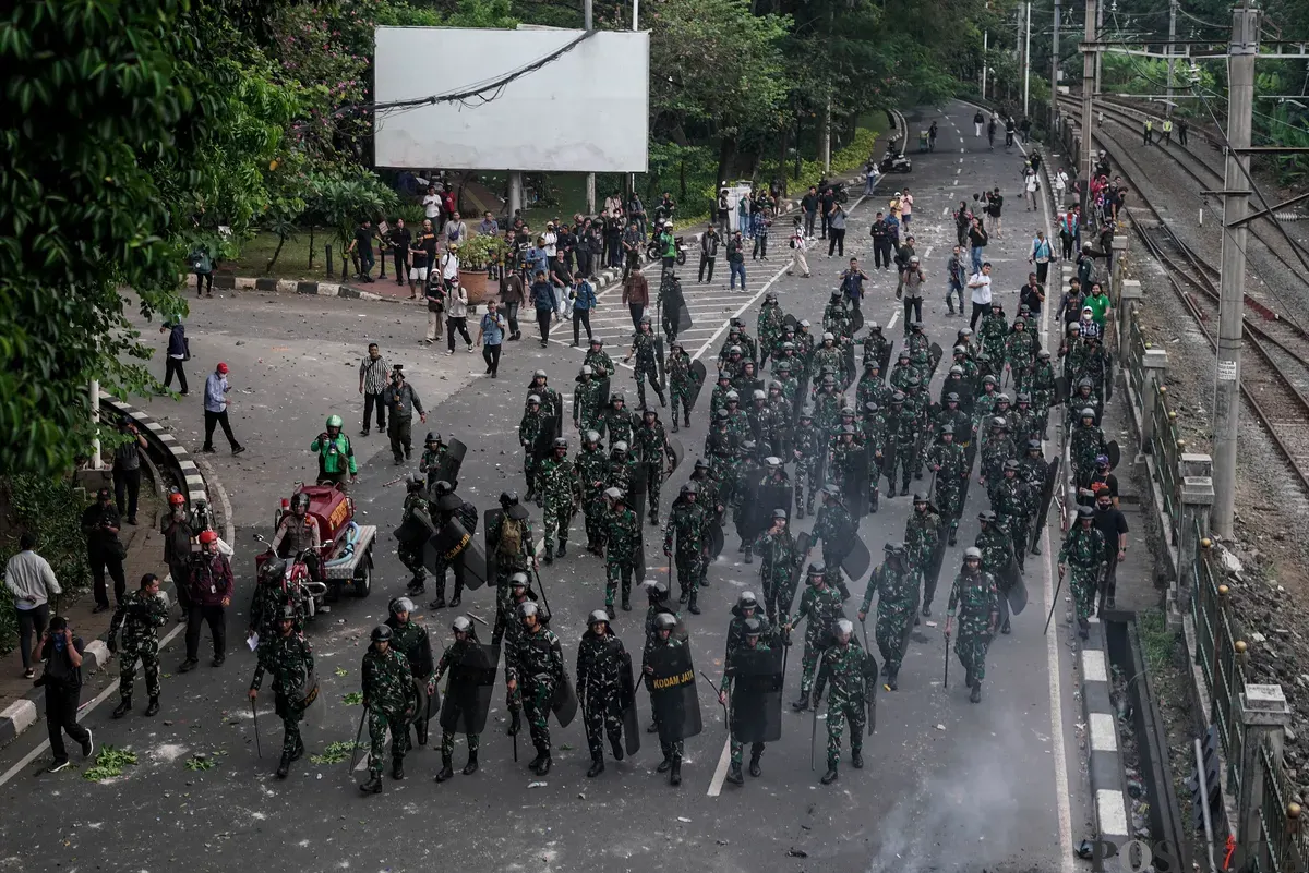 Sejumlah massa aksi berhadapan dengan aparat saat demo di belakang DPR dan Pejompongan, Jakarta, Senin, 25 Agustus 2025. (Sumber: Poskota/Bilal Nugraha Ginanjar)