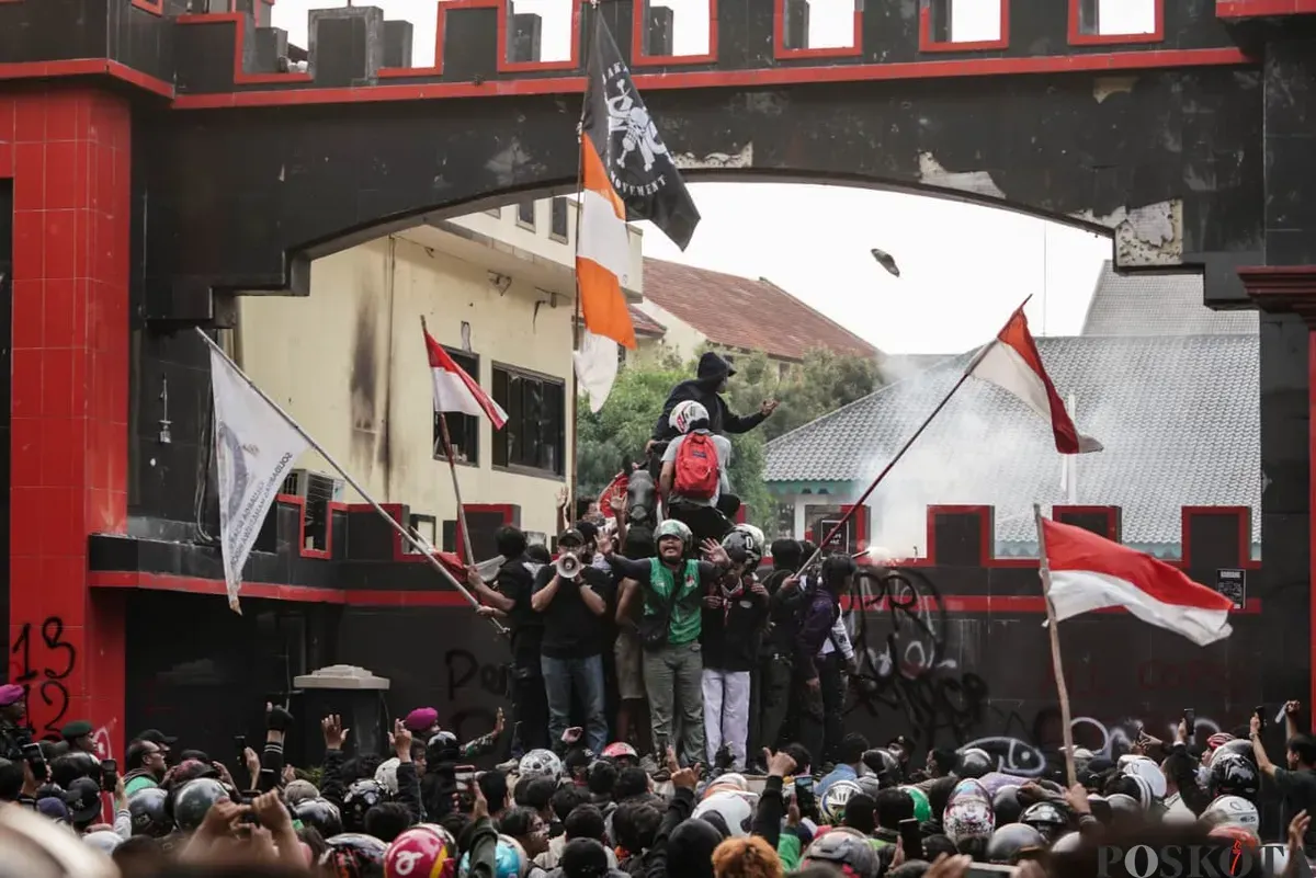 Demonstran beratribut ojol terlihat menenangkan massa aksi saat unjuk rasa di depan Satuan Brimob Polda Metro Jaya, Kecamatan Senen, Jakarta Pusat, Jumat, 29 Agustus 2025. (Sumber: Poskota/Bilal Nugraha Ginanjar)