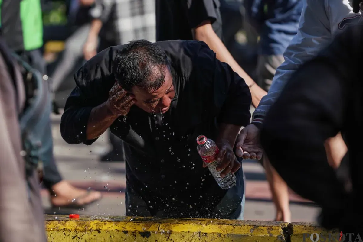 Seorang massa aksi membasuh wajah saat demonstrasi di Mako Brimob Polda Metro Jaya, Kwitang, Jakarta Pusat, Jumat, 29 Agustus 2025. (Sumber: Poskota/Bilal Nugraha Ginanjar)