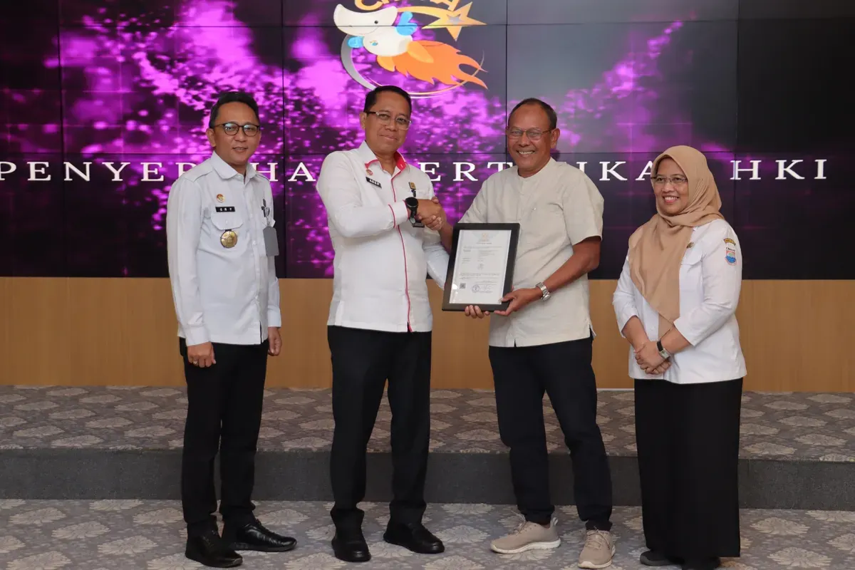 Pejabat Pemerintah Kota Cimahi bersama perwakilan Kemenkumham Jawa Barat menyerahkan sertifikat Hak Kekayaan Intelektual (HAKI) kepada salah satu penerima dalam rangkaian CHiMA Awards 2025. (Sumber: Diskominfo Kota Cimahi)
