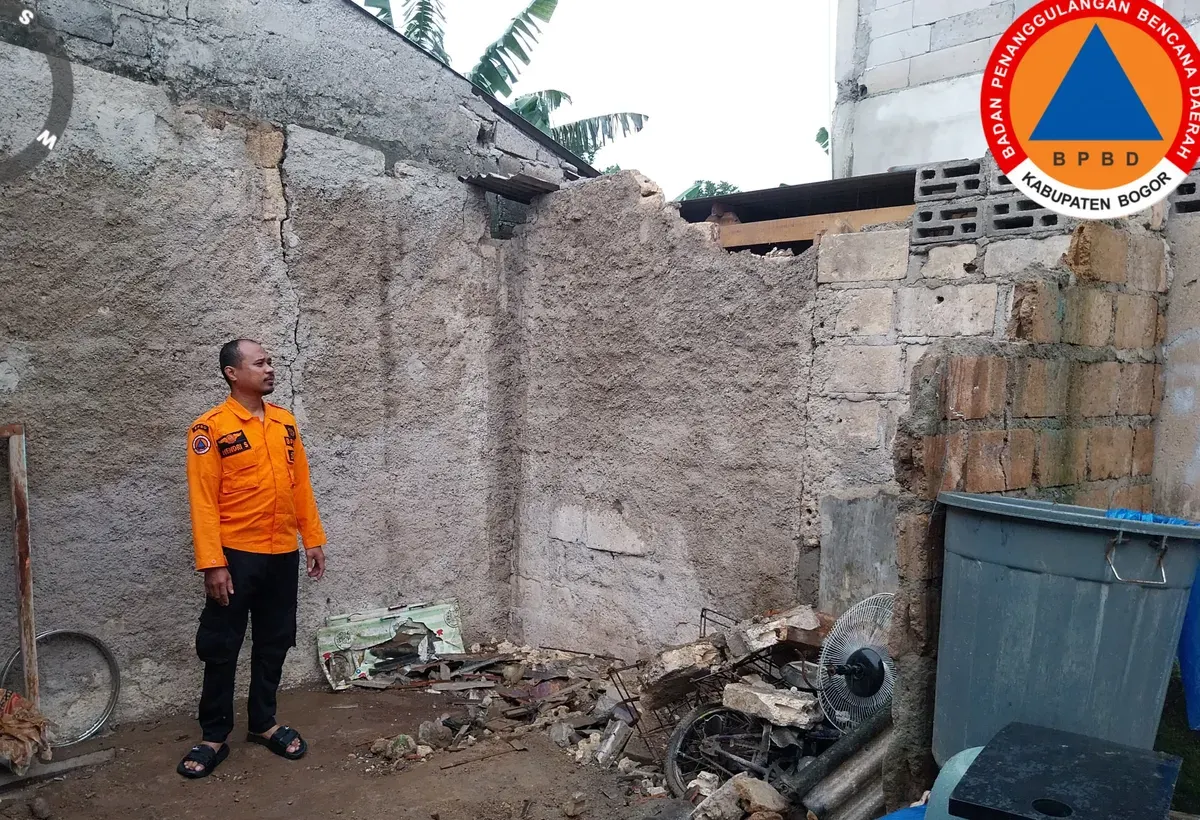 Petugas BPBD Kabupaten Bogor meninjau rumah warga yang terdampak longosran TPT Hotel. (Sumber: BPBD Kabupaten Bogor)