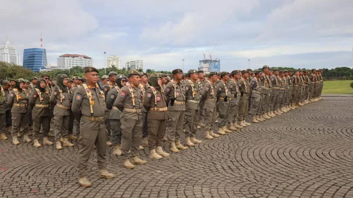 Ribuan personel Satpol PP DKI Jakarta saat menggelar apel gelar pasukan kesiapan pengamanan menjelang Hari Raya Natal 2025 dan Tahun Baru 2026 di Monas Sisi Selatan, Jakarta Pusat, pada Kamis, 18 Desember 2025. (Sumber: Kominfotik Satpol PP Jakarta)