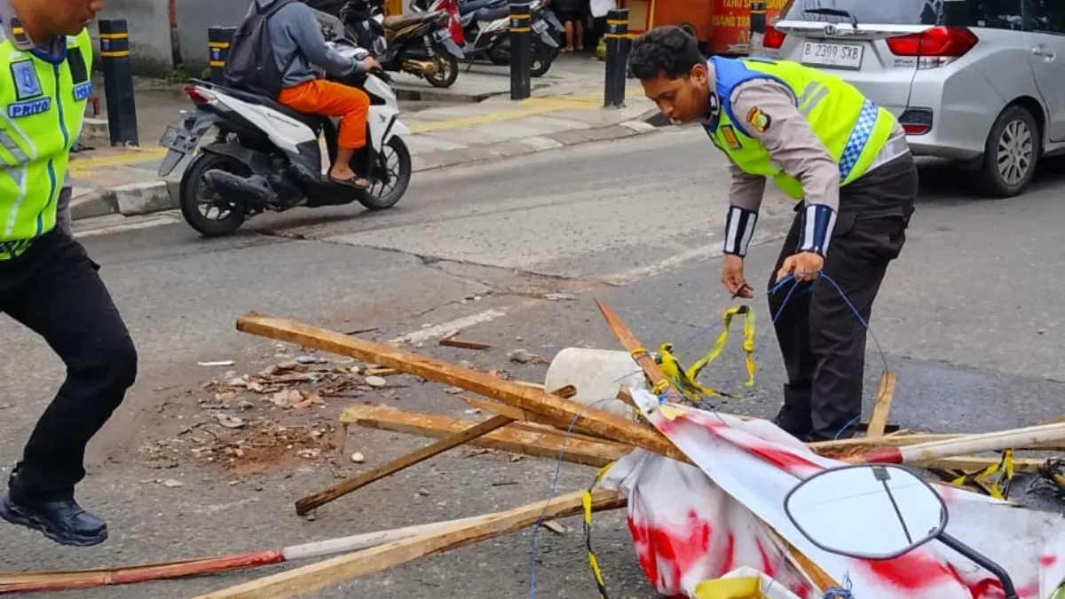 Anggota Kanit Lantas Polsek Cinere membersihkan sisa-siang puing pengerjaan proyek Jalan Cinere. (Sumber: Lantas Polsek Cinere)