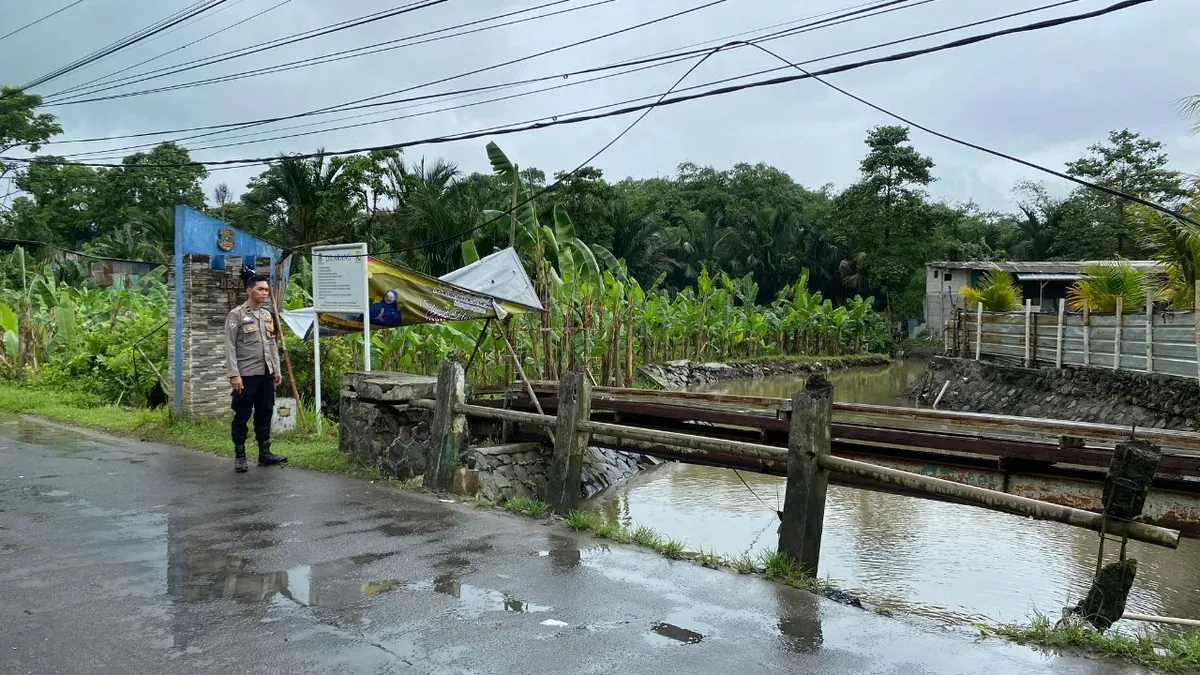 Anggota Polsek Panongan saat melakukan pengecekan debit air aliran Sungai Cirarab, Kabupaten Tangerang. (Sumber: Dok. Polsek Panongan)