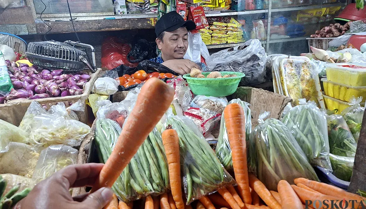 Pedagang sayuran melayani pembeli di Pasar Depok Jaya. Wortel jadi salah satu komoditas yang harganya naik jelang Natal 2025 dan Tahun Baru 2026. (Sumber: POSKOTA | Foto: Angga Pahlevi)