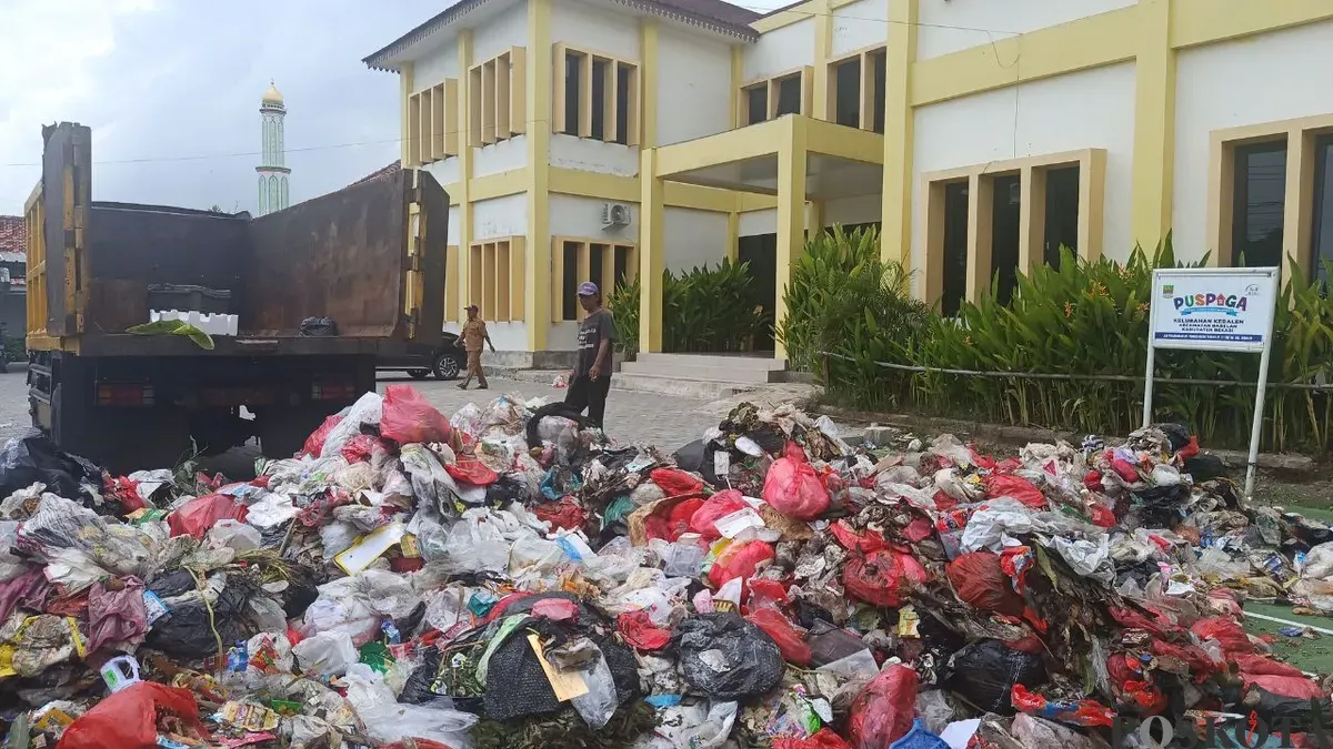 Tumpukan sampah rumah tangga menggunung di halaman Kantor Kelurahan Kebalen, Kecamatan Babelan, Kabupaten Bekasi, Senin, 29 Desember 2025. (Sumber: Poskota/Nurpini Aulia Rapika)