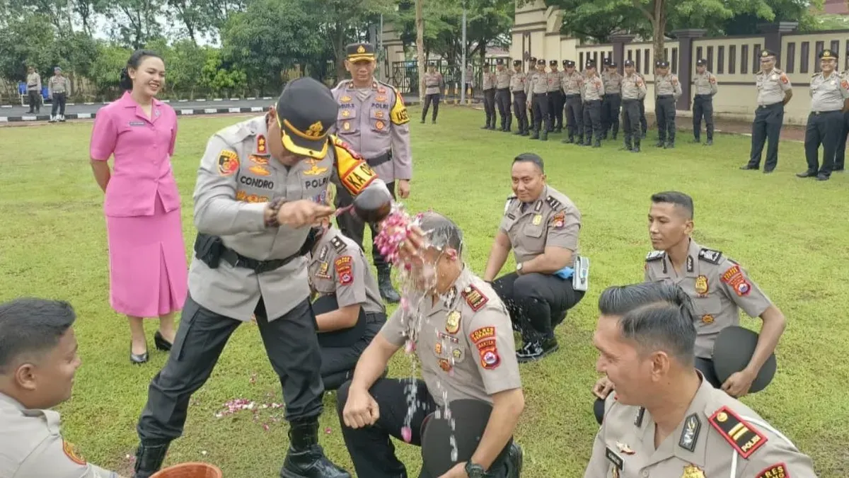 Kapolres Serang, AKBP Condro Sasongko melaksanakan tradisi penyiraman air kembang kepada personel yang naik pangkat, Rabu, 31 Desember 2025. (Sumber: Dok. Polres Serang)