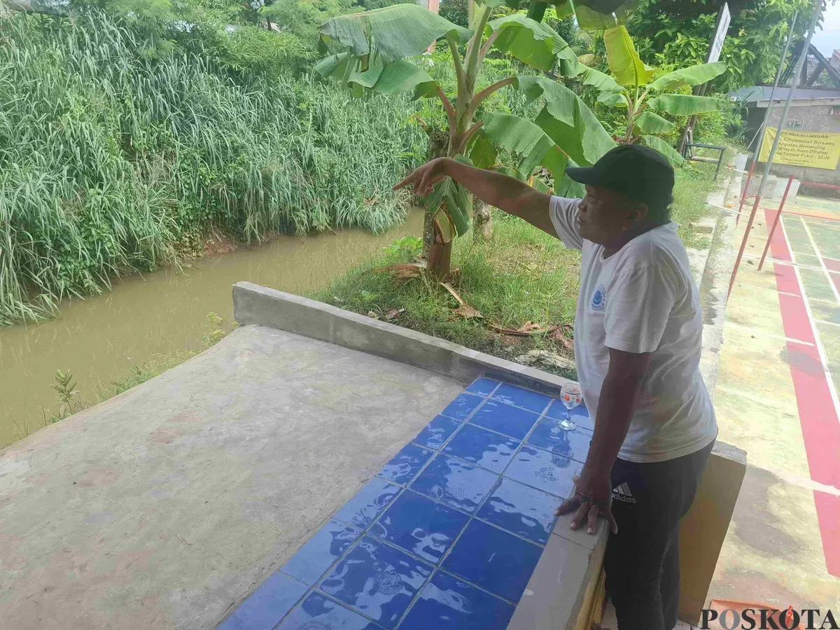 Warga menunjukan lokasi kali yang kerap menjadi penyebab langganan banjir di musim penghujan. (Sumber: Poskota/Angga Pahlevi)